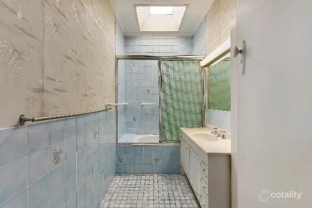 Mitchelton bathroom before renovation: original blue tiles and shower curtain